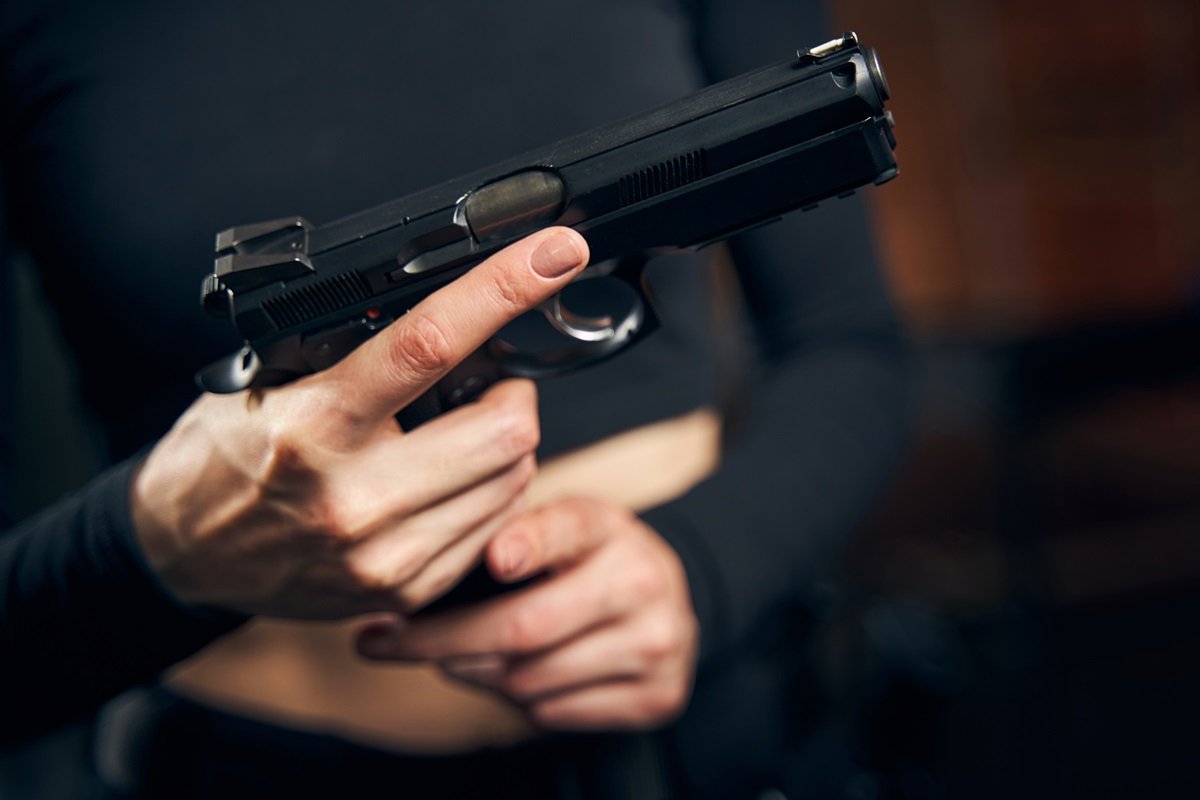 A close-up of a woman holding a gun