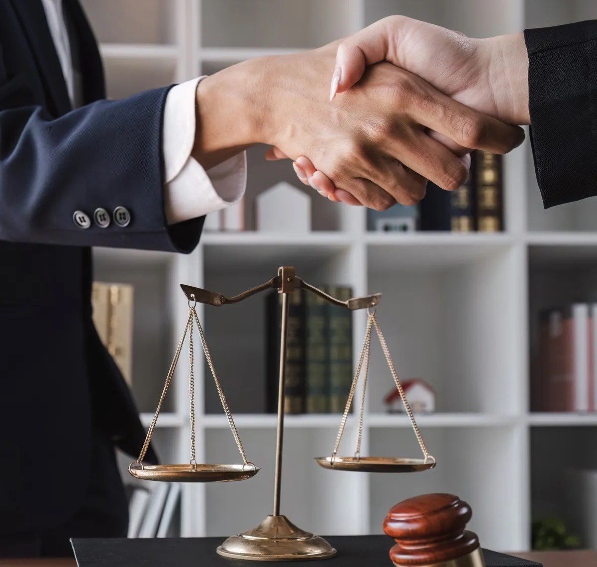A lawyer and client shaking hands over a scale