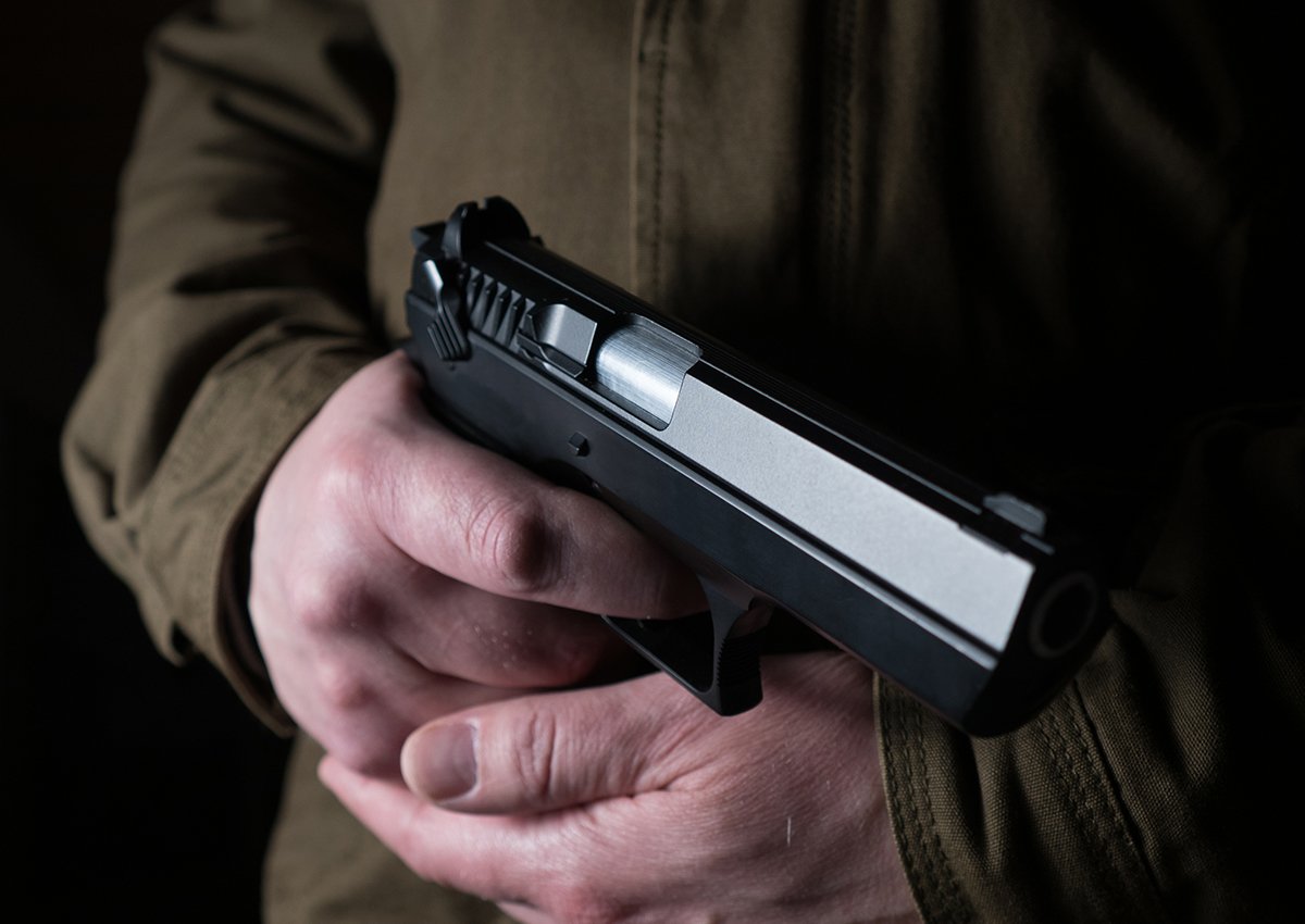 A close-up of a woman holding a gun